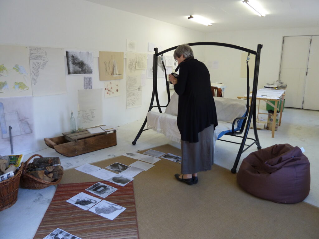 woman stands above artistic pictures of mice and takes photos of them.